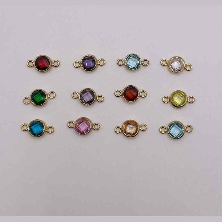 Gold-filled birth stone connectors with colored gemstones on a light gray background